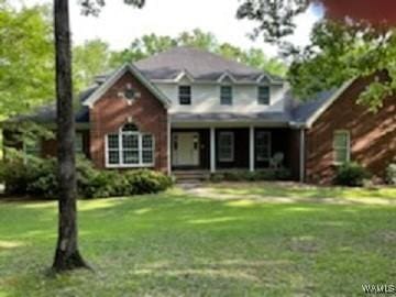 traditional-style house featuring a front lawn and a porch