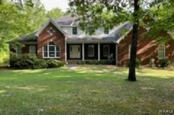 traditional-style home featuring a front lawn
