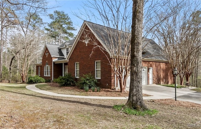 view of front facade featuring an attached garage, concrete driveway, and brick siding