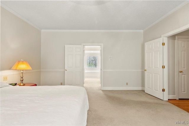 bedroom featuring light carpet, baseboards, ornamental molding, and a textured ceiling