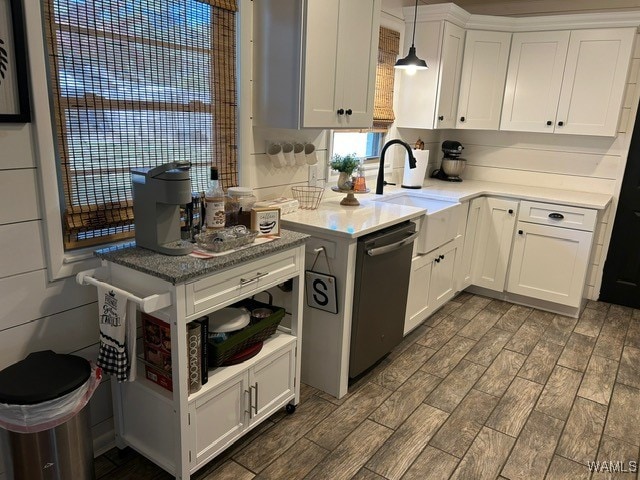 kitchen with pendant lighting, sink, stainless steel dishwasher, and white cabinets