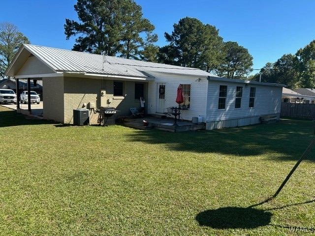 back of house featuring a yard and central AC unit