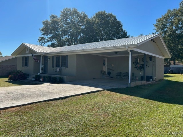 rear view of property with a carport and a lawn