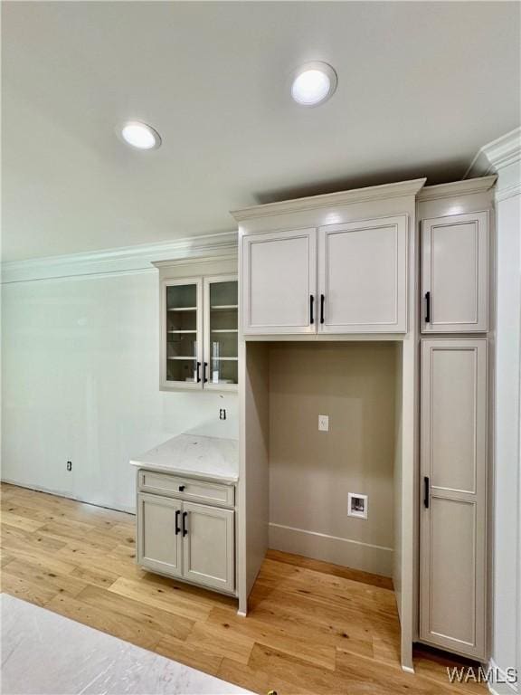 laundry area featuring recessed lighting, light wood-style flooring, and baseboards