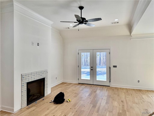 unfurnished living room featuring french doors, a fireplace, light wood finished floors, visible vents, and baseboards