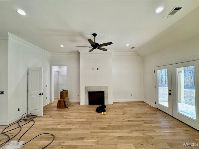 unfurnished living room with french doors, a fireplace, visible vents, light wood-style flooring, and ornamental molding