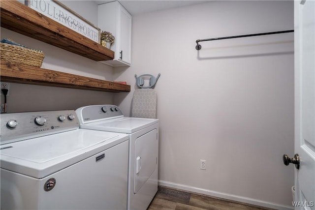 laundry area featuring dark hardwood / wood-style flooring, washing machine and dryer, and cabinets