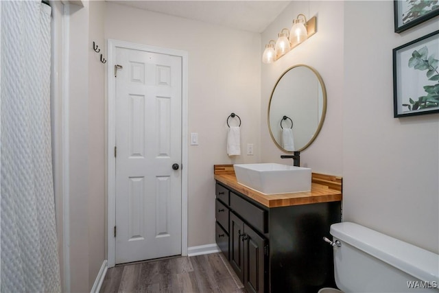 bathroom featuring vanity, toilet, and hardwood / wood-style floors