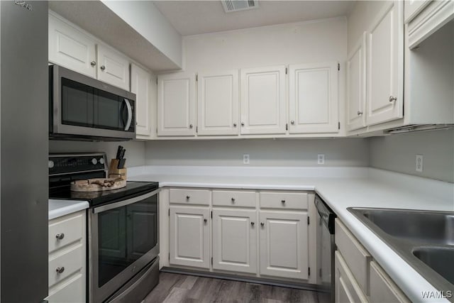 kitchen featuring stainless steel appliances, white cabinetry, dark hardwood / wood-style floors, and sink