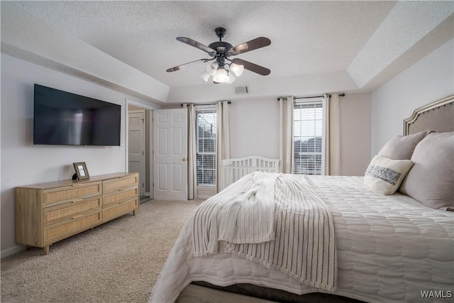 carpeted bedroom featuring ceiling fan and a textured ceiling