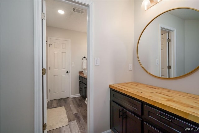 bathroom featuring vanity, hardwood / wood-style flooring, and toilet