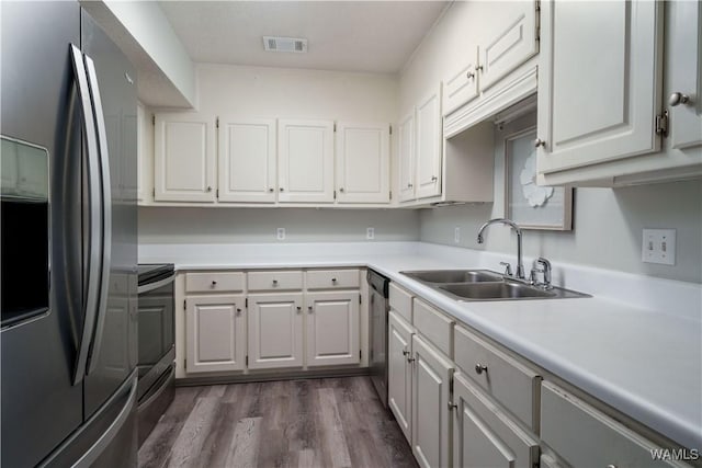 kitchen with white cabinetry, sink, dark hardwood / wood-style flooring, and stainless steel appliances