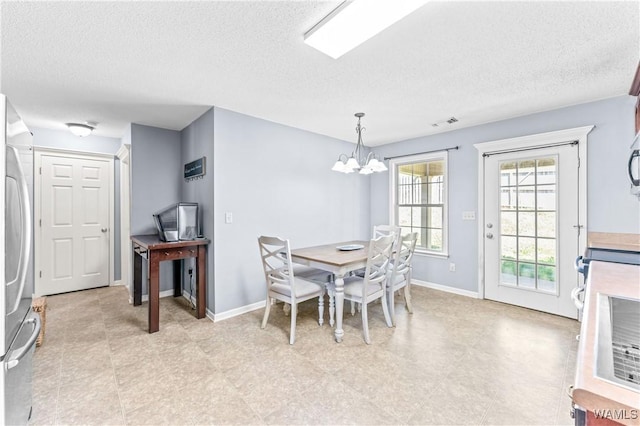 dining area featuring a textured ceiling, baseboards, visible vents, and a chandelier