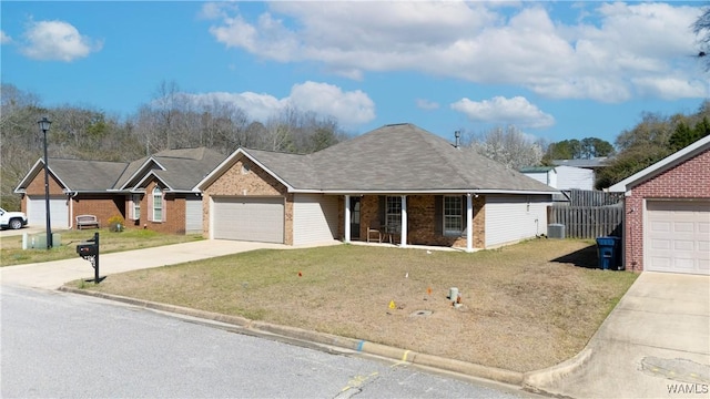 ranch-style home with a porch, an attached garage, concrete driveway, a front lawn, and brick siding