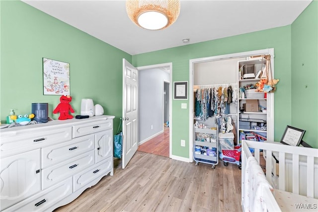 bedroom with light wood-style floors, a closet, and baseboards