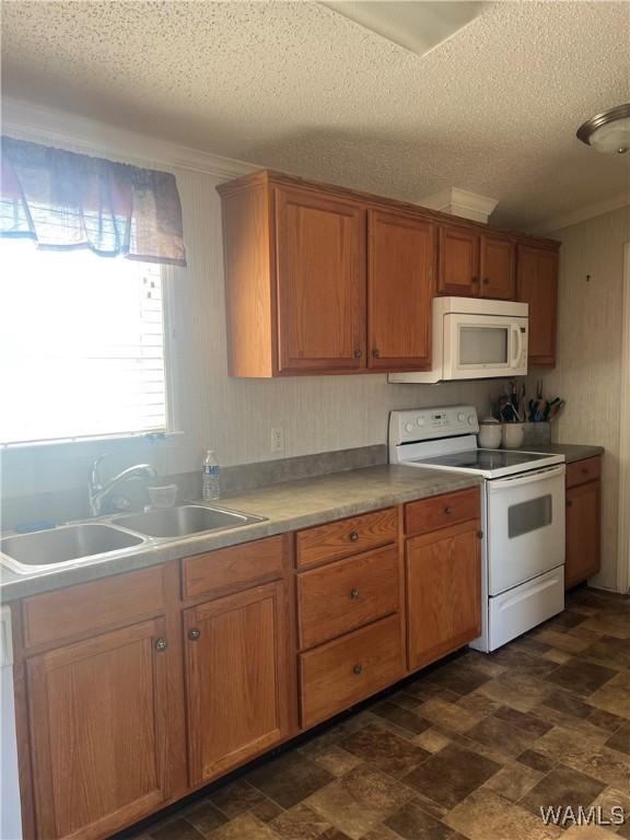 12443 Reed Simpson Rd, Northport, AL 35475 - kitchen with white appliances, a sink, a textured ceiling, brown cabinets, and ornamental molding