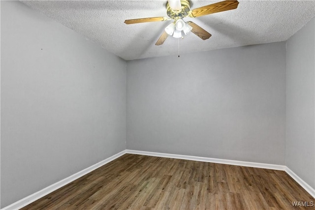 unfurnished room with a ceiling fan, dark wood finished floors, a textured ceiling, and baseboards