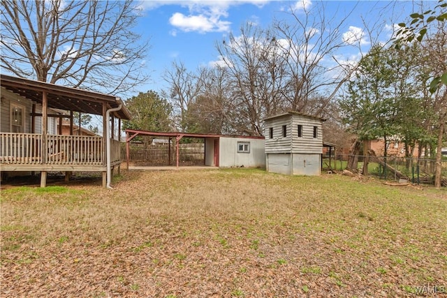 view of yard with a carport, a shed, a fenced backyard, and an outbuilding