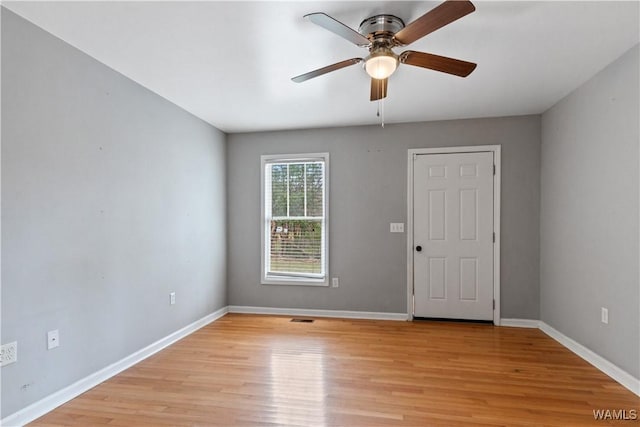 spare room featuring light wood-style floors, ceiling fan, and baseboards