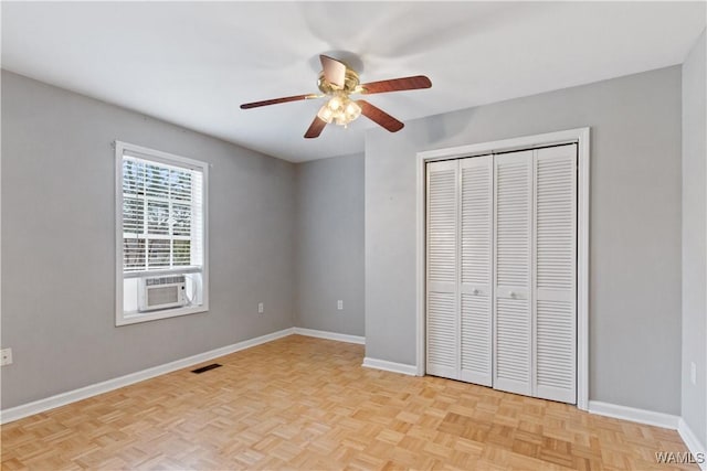 unfurnished bedroom featuring a closet, visible vents, ceiling fan, cooling unit, and baseboards