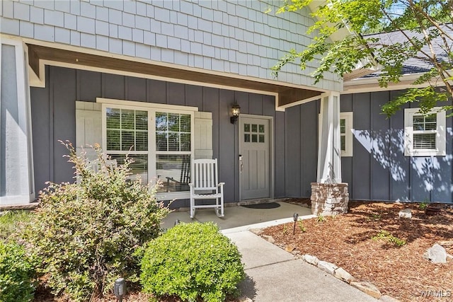 view of exterior entry featuring a porch and board and batten siding