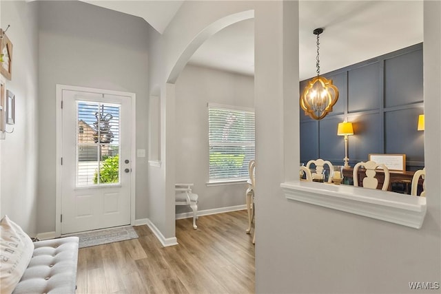 2757 Lily Cir, Northport, AL 35473 - foyer entrance featuring a chandelier, arched walkways, plenty of natural light, and wood finished floors