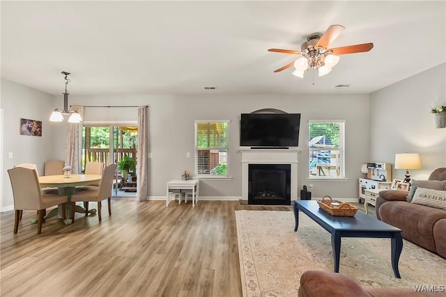 2757 Lily Cir, Northport, AL 35473 - living room with light wood-style floors, ceiling fan, and a fireplace with flush hearth