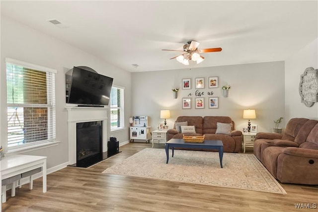 2757 Lily Cir, Northport, AL 35473 - living area with ceiling fan, a fireplace with raised hearth, and light wood-style floors