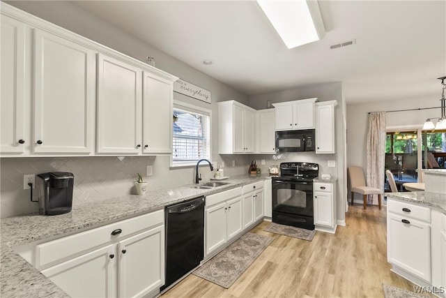 2757 Lily Cir, Northport, AL 35473 - kitchen featuring black appliances, white cabinetry, light wood-style floors, tasteful backsplash, and light stone counters