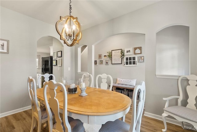 2757 Lily Cir, Northport, AL 35473 - dining space with a chandelier, arched walkways, and wood finished floors