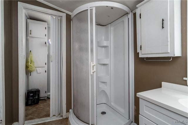 bathroom with vanity, ornamental molding, and a stall shower
