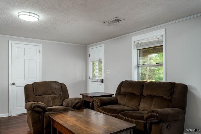 living room with crown molding, dark wood-style flooring, a textured ceiling, and visible vents
