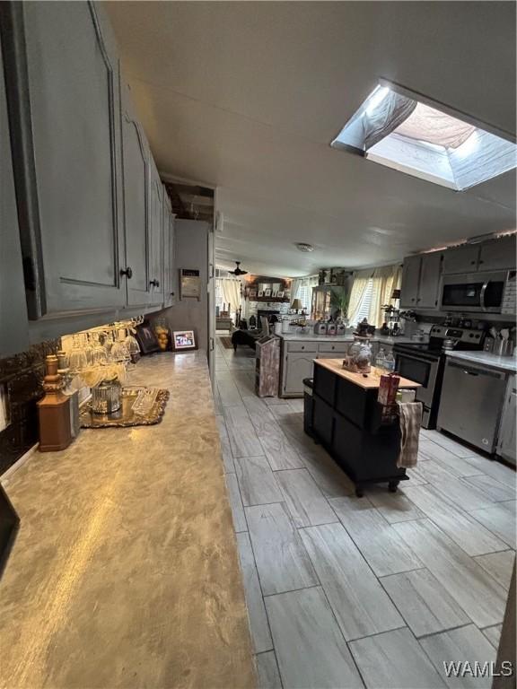 743 Greentree Dr, West Blocton, AL 35188 - kitchen with stainless steel appliances, a skylight, and gray cabinetry