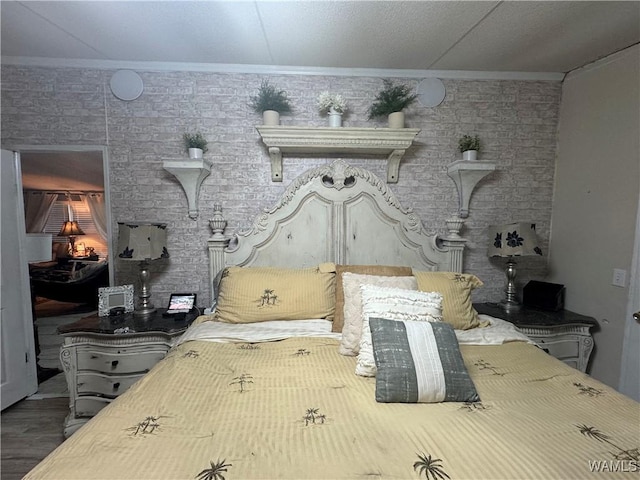 bedroom featuring ornamental molding and wood finished floors