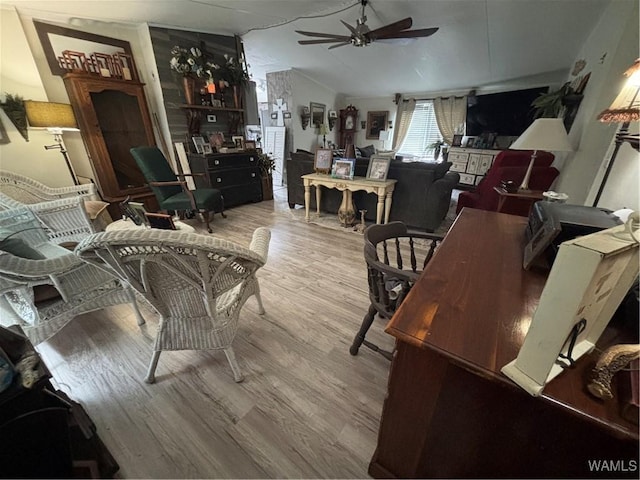 living room with ceiling fan, wood finished floors, and lofted ceiling