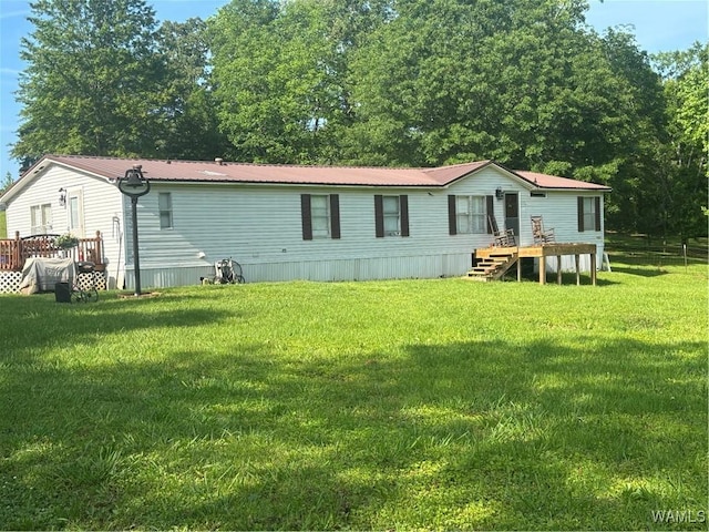 rear view of property featuring a yard and metal roof