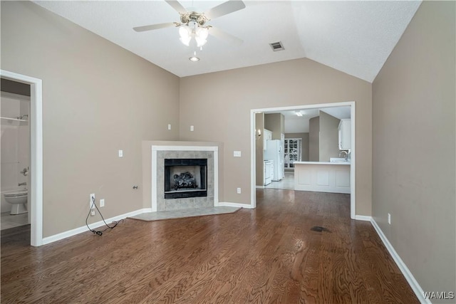 6128 Covington Villas Dr, Tuscaloosa, AL 35405 - unfurnished living room featuring vaulted ceiling, ceiling fan, wood finished floors, and a tiled fireplace