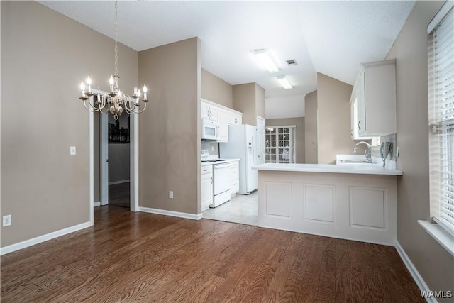6128 Covington Villas Dr, Tuscaloosa, AL 35405 - kitchen with white appliances, wood finished floors, a chandelier, lofted ceiling, and light countertops
