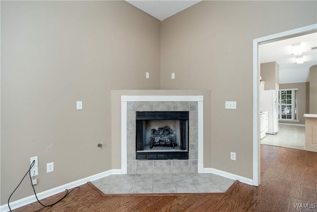 6128 Covington Villas Dr, Tuscaloosa, AL 35405 - detailed view of wood finished floors, a tile fireplace, and freestanding refrigerator