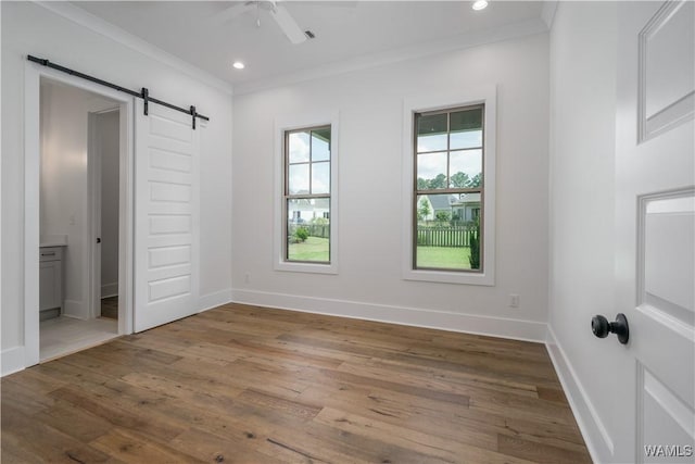 407 Edgefield Mews Cir, Tuscaloosa, AL 35406 - unfurnished bedroom with a barn door, crown molding, wood finished floors, recessed lighting, and ensuite bath