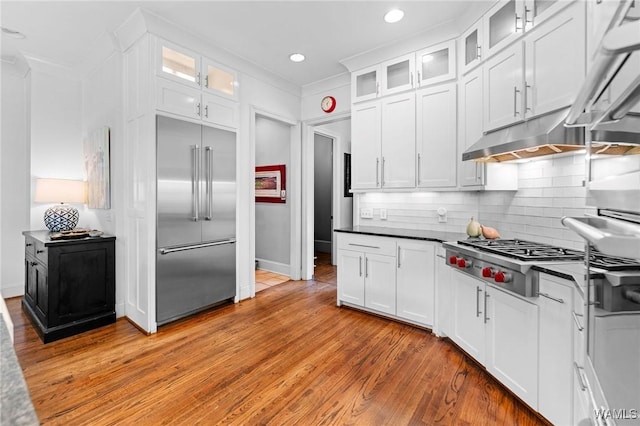 120 Magnolia Cir, Centreville, AL 35042 - kitchen with stainless steel appliances, white cabinetry, light wood finished floors, tasteful backsplash, and dark countertops