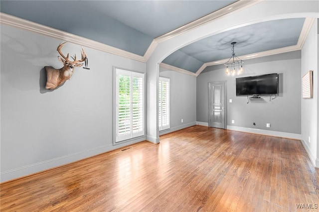120 Magnolia Cir, Centreville, AL 35042 - unfurnished living room featuring a chandelier, arched walkways, wood finished floors, crown molding, and lofted ceiling
