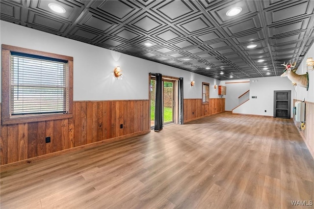 120 Magnolia Cir, Centreville, AL 35042 - unfurnished living room featuring wainscoting, wood walls, light wood-type flooring, stairway, and an ornate ceiling