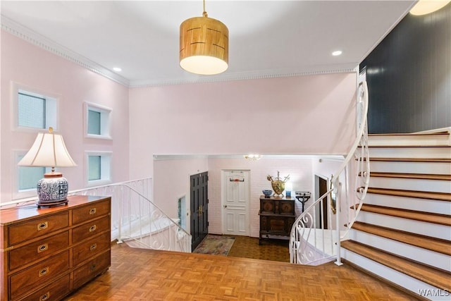 entryway with ornamental molding and stairs