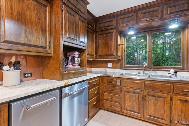 kitchen with stainless steel dishwasher, a sink, brown cabinetry, and light tile patterned floors