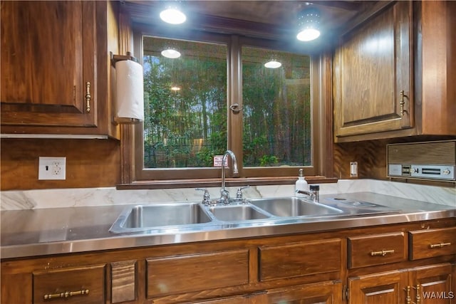 kitchen featuring light countertops, brown cabinetry, and a sink