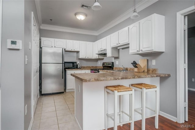 303 Helen Keller Blvd Unit B319, Tuscaloosa, AL 35404 - kitchen with appliances with stainless steel finishes, crown molding, a peninsula, white cabinetry, and under cabinet range hood