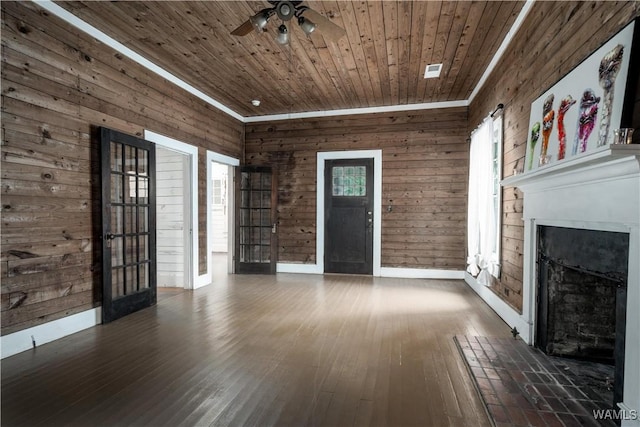 221 3rd Ct SW, Fayette, AL 35555 - unfurnished living room with a fireplace, wood ceiling, a ceiling fan, hardwood / wood-style floors, and wood walls