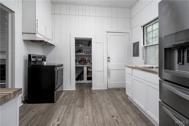 221 3rd Ct SW, Fayette, AL 35555 - kitchen featuring stainless steel range oven, light wood-type flooring, white cabinetry, and under cabinet range hood