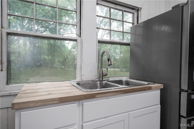 221 3rd Ct SW, Fayette, AL 35555 - kitchen with butcher block counters, freestanding refrigerator, and white cabinets